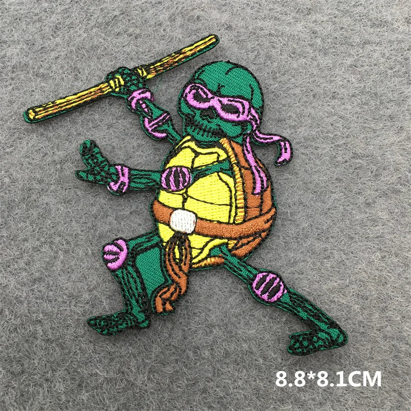 Embroidered patch of a turtle character with a sword on a gray background