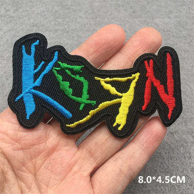 Colorful embroidered patch held in a hand with dimensions indicated