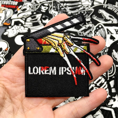 Embroidered patch with a design and 'LOREM IPSUM' text held in a hand, surrounded by other patches.