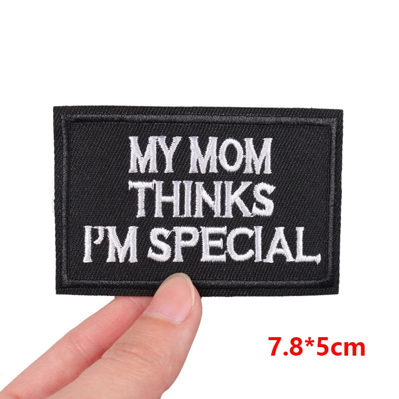 Black patch with white text 'MY MOM THINKS I'M SPECIAL' held by a hand, with dimensions displayed.