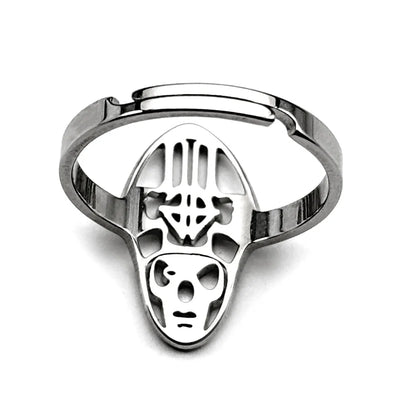 Silver metal ring with an intricately designed face featuring cut-outs and geometric patterns. The tone is modern and edgy, highlighting craftsmanship.