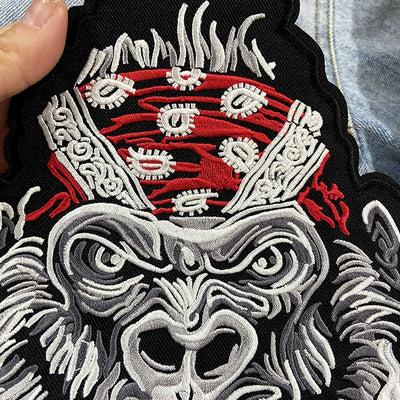 Embroidered patch with a detailed design featuring red, white, and black colors.