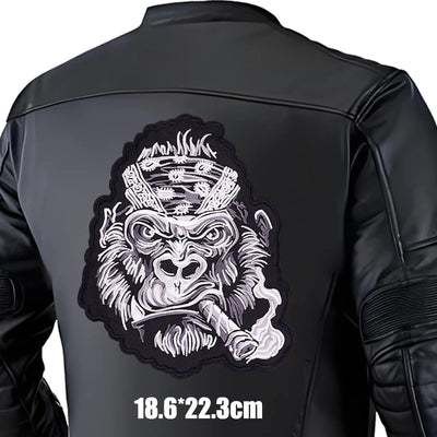Black leather jacket with a monkey patch on the back, size indicated.