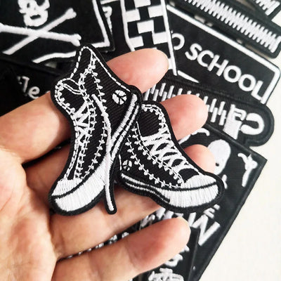 Black and white shoe patch held by a hand with more patches in the background.