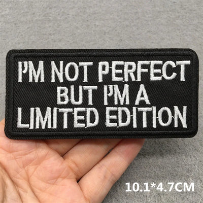 Embroidered patch with text 'I'm not perfect but I'm a limited edition' held in a hand.