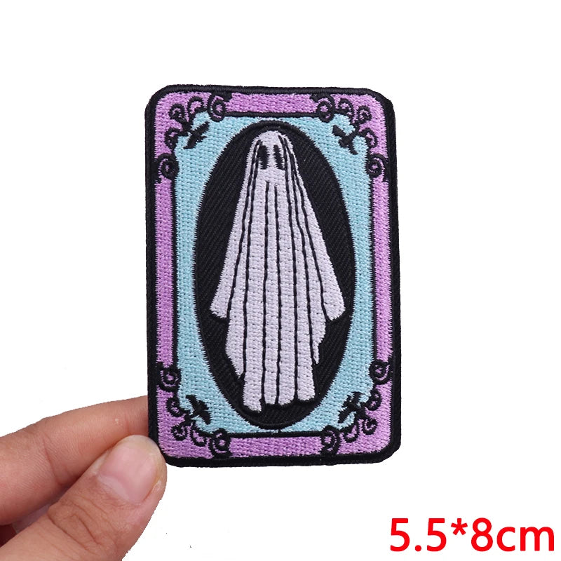 Embroidered patch of a ghost in a frame held by a hand with dimensions displayed.