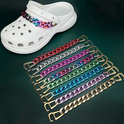 White clog shoe with colorful chain strap on a dark green background