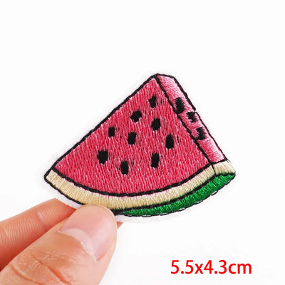 Watermelon slice patch held by a hand with size label '5.5x4.3cm' on a white background
