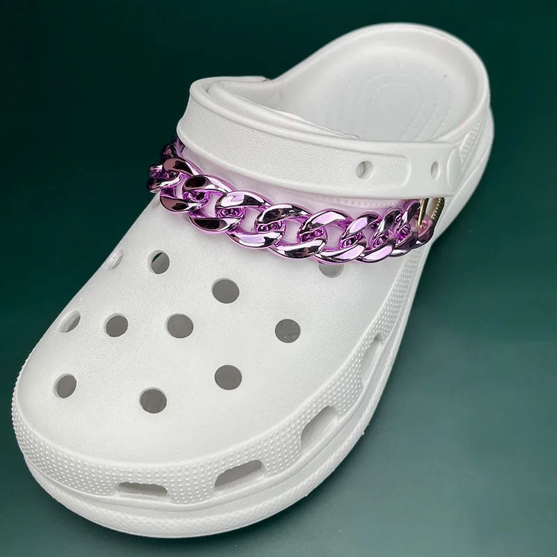 White clog shoe with a purple chain accessory on a green background