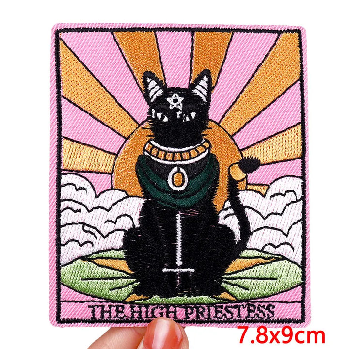 Embroidered patch of a black cat with a colorful background
