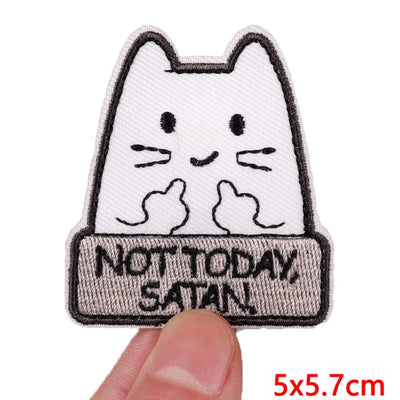 Embroidered patch with a cat design and 'Not Today Satan' text held by a hand.