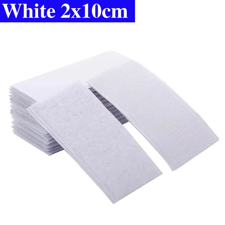 White Velcro pads with dimensions 2x10cm on a white background