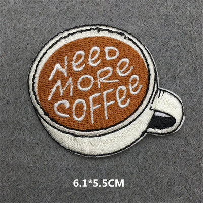 Embroidered patch of a coffee cup with 'Need More Coffee' text on a gray background