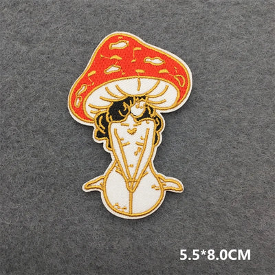 Embroidered patch of a mushroom with a face on a gray background