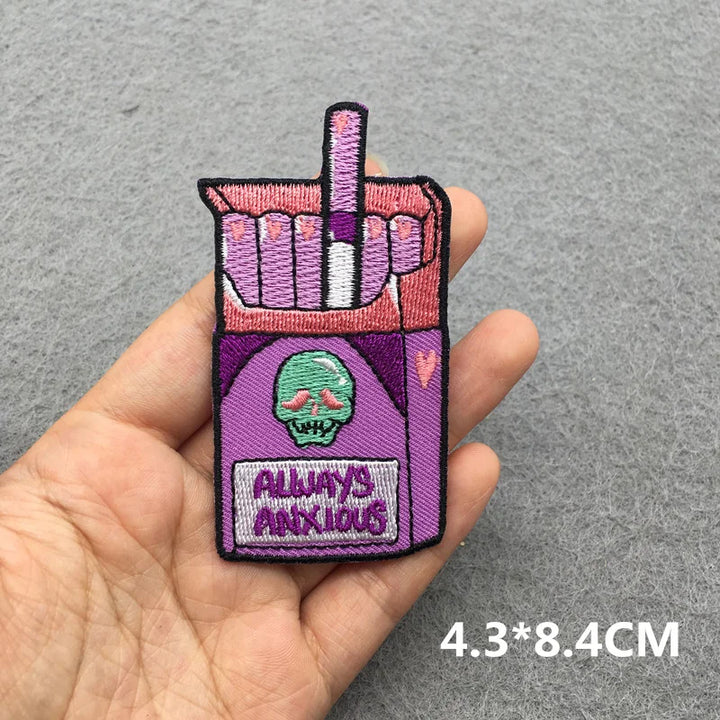 Embroidered patch of a cigarette pack with a hand holding a cigarette, labeled &