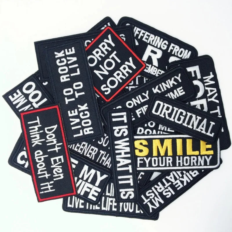 Collection of black patches with various printed text on a white background