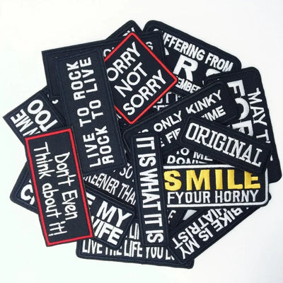 Collection of black patches with various printed text on a white background