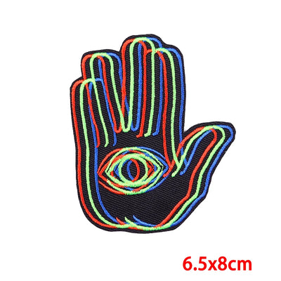 Colorful hand-shaped patch with an eye design on a white background