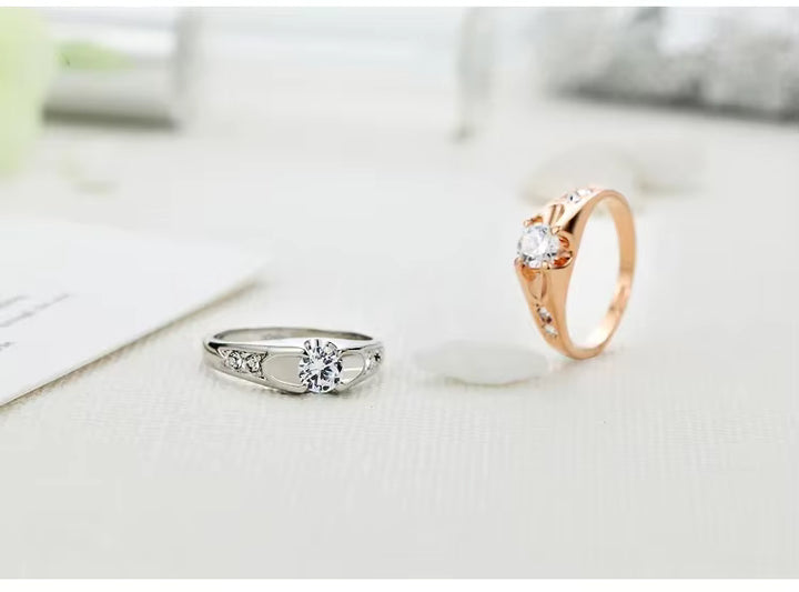 Two zircon rings, one silver and one rose gold, on a light background.