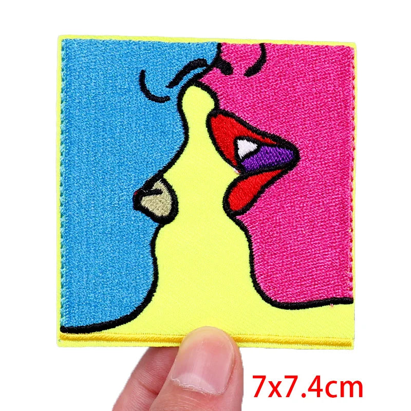 Colorful patch of a cartoon character held by a hand with dimensions 7x7.4cm.