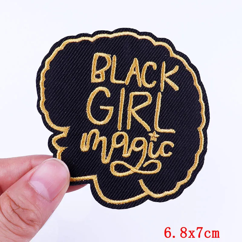 BlackGirlMagic patch held by a hand with a white background