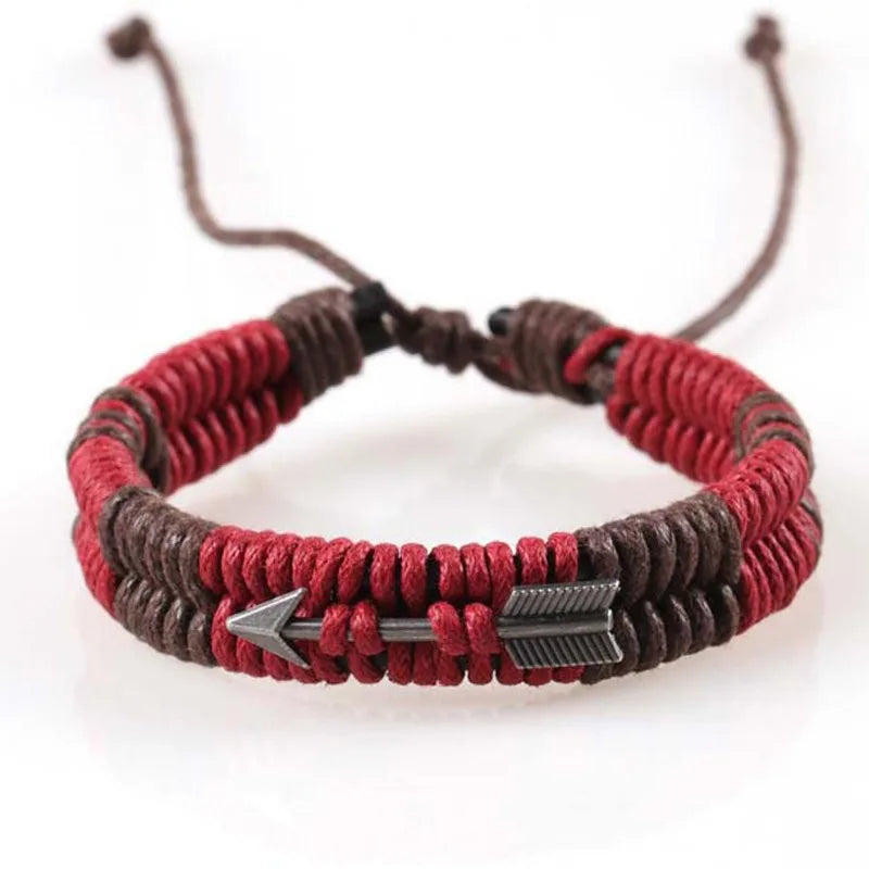 Bracelet with red and brown cord and arrow charm on a white background