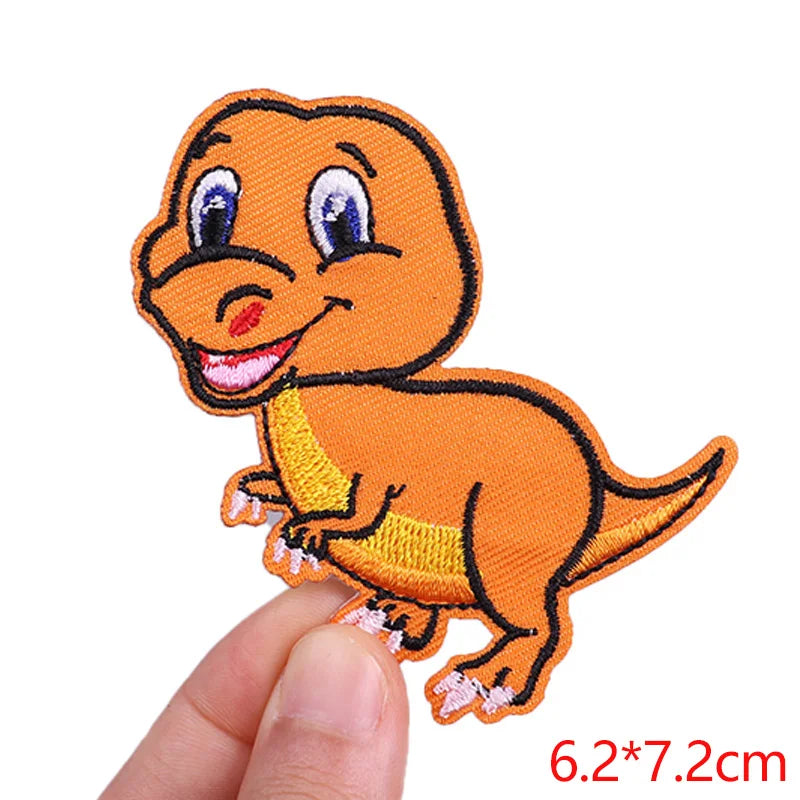 Cartoon dinosaur patch held by a finger on a white background
