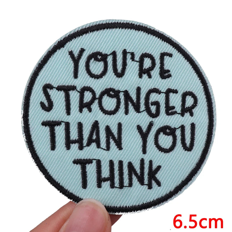 Circular patch with motivational text held by a hand, size indicated as 6.5cm.