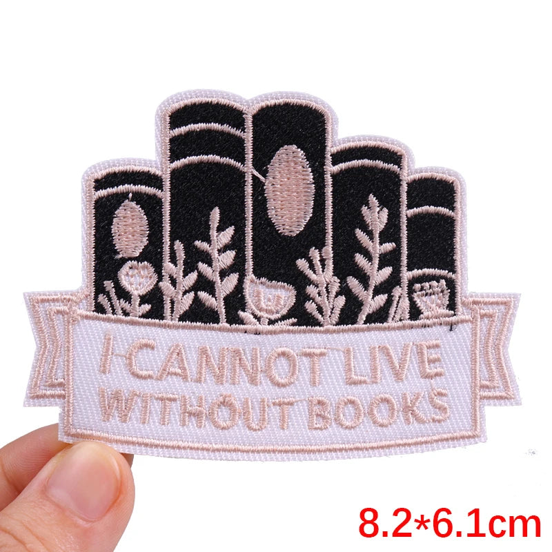 Embroidered patch with book design and 'I cannot live without books' text held by a hand.