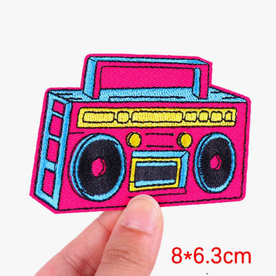 Colorful boombox patch held by a hand with dimensions displayed.