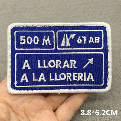 Embroidered patch with text and symbols on a gray background