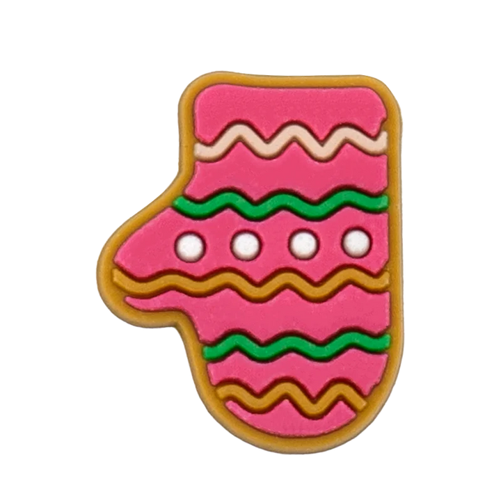 Shoe charm ornament of Pink gingerbread cookie shaped like a stocking with green and brown decorations on a white background