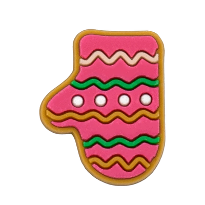 Shoe charm ornament of Pink gingerbread cookie shaped like a stocking with green and brown decorations on a white background