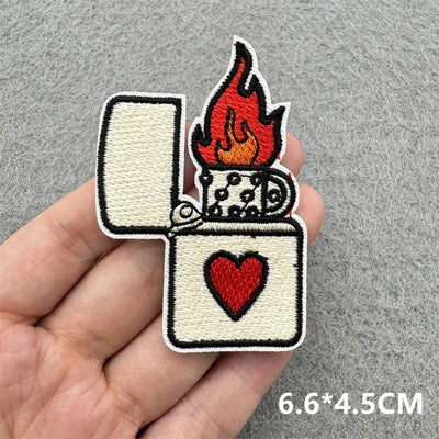 Patch of a lighter with flames and a heart held in a hand on a gray background