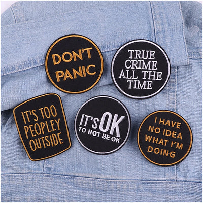 Five patches with humorous text on a denim background