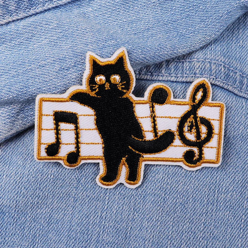 Black cat patch on a denim jacket with musical notes