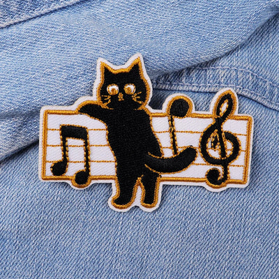 Black cat patch on a denim jacket with musical notes