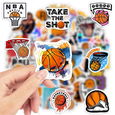 Basketball-themed stickers with a hand holding one of them, set against a blurred background of people and basketballs.