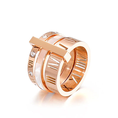 Rose gold ring with Roman numeral design on a white background