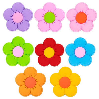 Set of colorful flower-shaped shoe charms on a white background