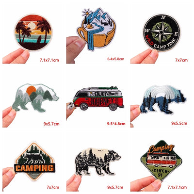 Collection of various camping-themed stickers held by hands with dimensions displayed.
