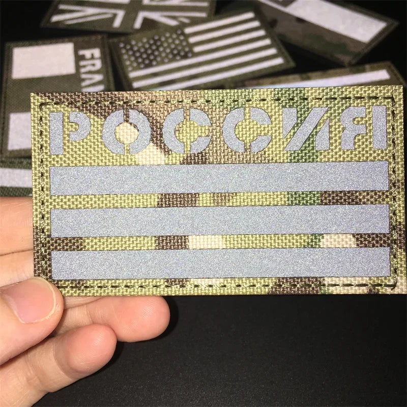 Russia Camouflage patch held by a hand against a dark background