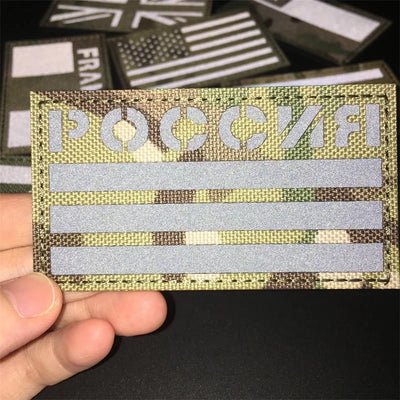 Russia Camouflage patch held by a hand against a dark background