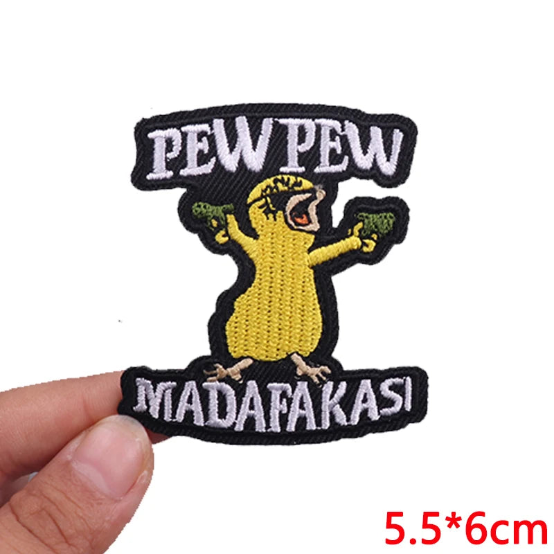 Embroidered patch with 'PEW PEW MADAFAKASI' text held by a hand on a white background.