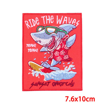 Embroidered patch with a shark riding a wave and text on a red background