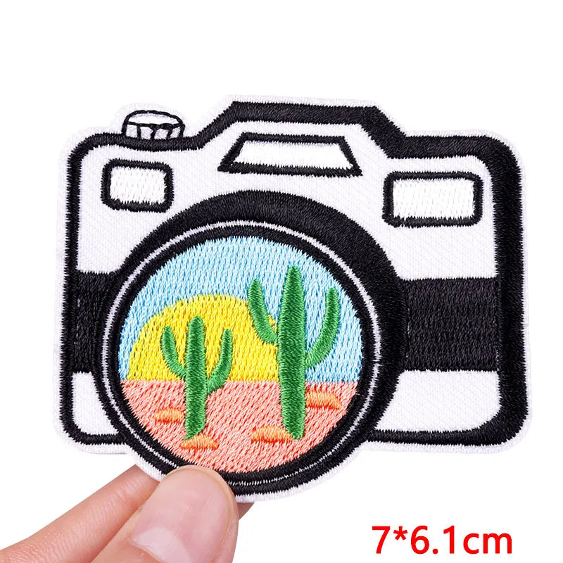 Camera-shaped patch with cactus design held by a hand, size 7*6.1cm.