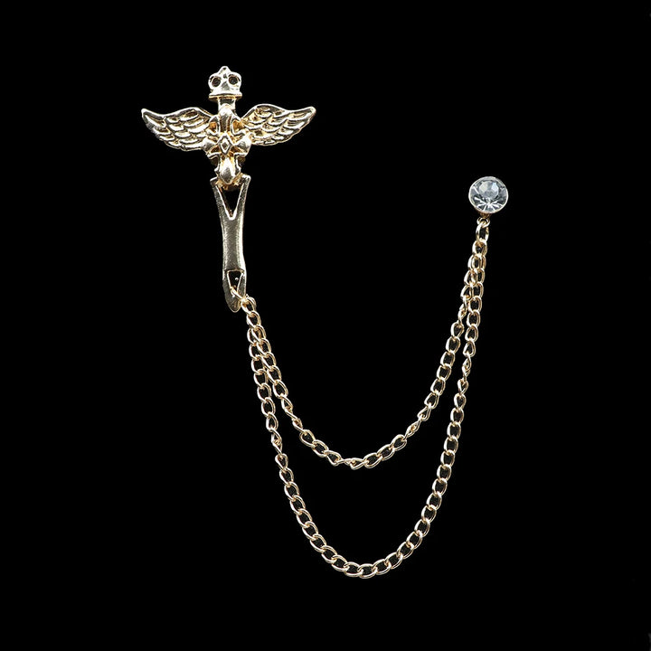 Metallic brooch with chain and gemstone on a black background