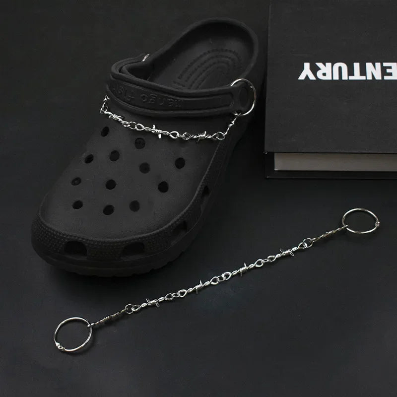 Black clog shoe with a chain attached on a dark background