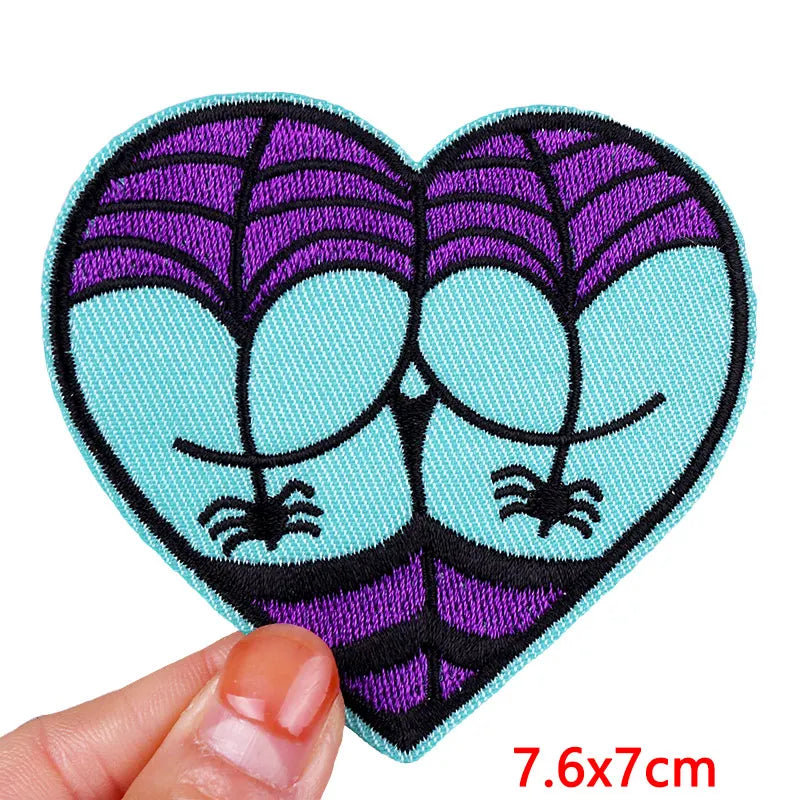 Heart-shaped patch with spider design held by a hand, size 7.6x7cm