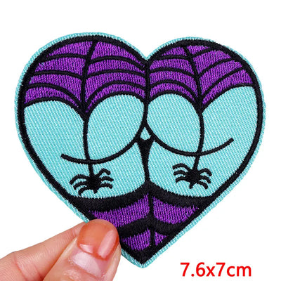 Heart-shaped patch with spider design held by a hand, size 7.6x7cm